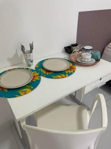 un tavolo bianco con due piatti sopra di Pousada hostel praia itapua a Salvador