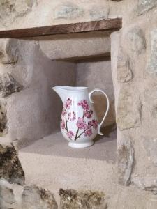 um vaso branco sentado numa parede de pedra em Casa Lidia - Antigua Posada Real em Valderrobres