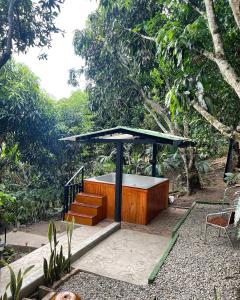 a bench with a table and stairs in a garden at Cabaña El Mirador - La Mesa in La Mesa