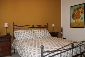 1 dormitorio con 1 cama y una pintura en la pared en B&B Ca' Teonghio, en Orgiano