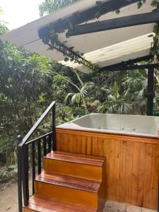 uma banheira de hidromassagem num deque de madeira com escadas em Cabaña El Mirador - La Mesa em La Mesa