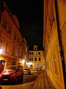une voiture garée dans une rue de la ville la nuit dans l'établissement Laxmi Happy Home in historical Prague, à Prague
