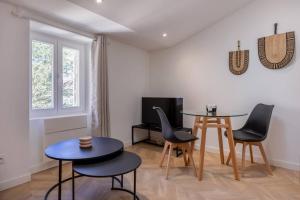 a living room with a table and chairs and a tv at L'escale douillette en hyper centre in La Rochelle