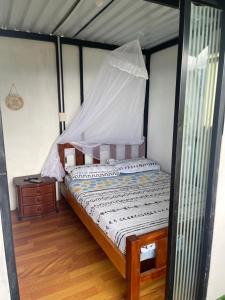 a bedroom with a bed with a mosquito net at Cabaña El Mirador - La Mesa in La Mesa