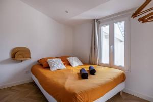 a bedroom with a bed with two shoes on it at L'escale douillette en hyper centre in La Rochelle