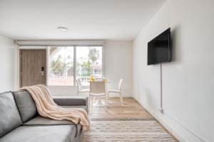 Beach House by ULIV في إنسينادا: غرفة معيشة مع أريكة وتلفزيون