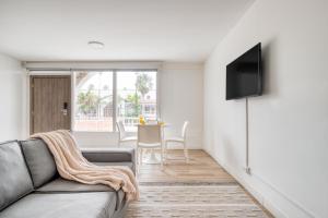 a living room with a couch and a tv at Beach House by ULIV in Ensenada
