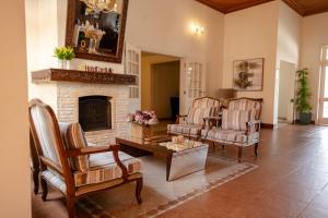 a living room with two chairs and a fireplace at Hotel Cordialle in São Roque