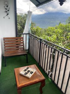 un banco y una mesa en un balcón con vistas en Cabaña El Mirador - La Mesa, en La Mesa
