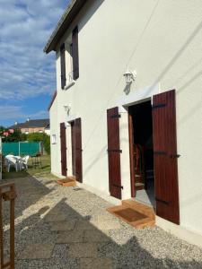 a white house with wooden doors and a courtyard at La Maison Cabourgeaise proche mer in Cabourg