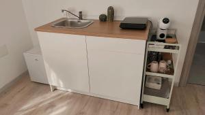 a kitchen counter with a sink and a shelf at Affittacamere Al Vicolo in San Bernardo