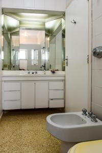 baño con lavabo y espejo grande en Bela's Suítes- 60 m da praia de Barequeçaba, en Barequeçaba