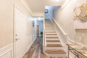 uma escadaria numa casa com paredes brancas e pisos de madeira em 3BR Townhouse w Perfect Location em Orlando