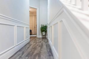 um corredor vazio com paredes brancas e pisos de madeira em 3BR Townhouse w Perfect Location em Orlando