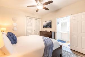 um quarto com uma cama branca e uma ventoinha de tecto em 3BR Townhouse w Perfect Location em Orlando