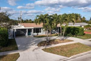 uma casa com palmeiras em frente em Paradise King Bed Crib Game Room Hot Tub 7m Beach Washer Dryer em Deerfield Beach