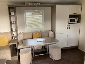 eine kleine Küche mit einem Tisch und Stühlen in einem Zimmer in der Unterkunft Lyons Robin Hood SEASCAPE in Meliden