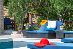 a pool with blue chairs and a red hat at Villa Marceline in Prvić Luka