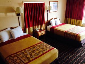 a hotel room with two beds with red curtains at Happy Holiday Motel in Myrtle Beach