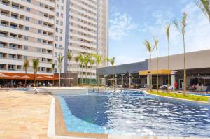 une piscine avec des palmiers et un bâtiment dans l'établissement Resort Enjoy Solar das Águas, à Olímpia