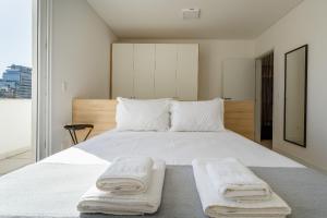 a bedroom with a large white bed with towels on it at Apto no centro com piscina RRI103 in Florianópolis +28 photos