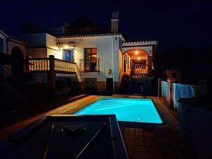 uma piscina em frente a uma casa à noite em Villa El Suspiro Frigiliana Nerja em Frigiliana