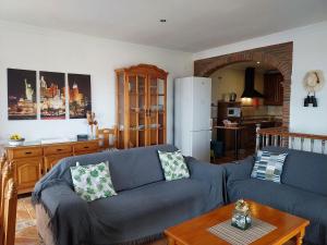 uma sala de estar com um sofá azul e uma mesa em Villa El Suspiro Frigiliana Nerja em Frigiliana