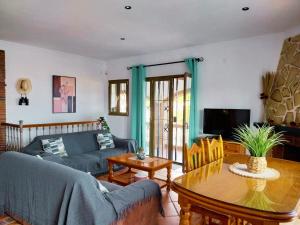 uma sala de estar com um sofá e uma mesa em Villa El Suspiro Frigiliana Nerja em Frigiliana