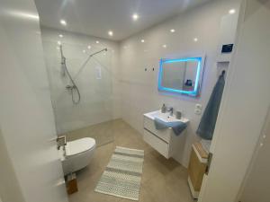 a white bathroom with a sink and a shower at Ferienwohnung Vulkaneifel in Stadtkyll