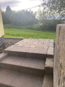 a set of stone steps in front of a yard at Ferienwohnung Vulkaneifel in Stadtkyll