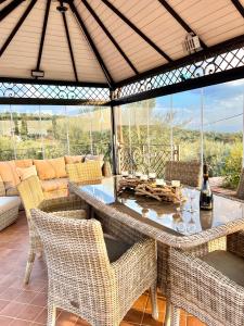 a patio with a table and chairs and a couch at Terre Villa Katia in Santa Maria di Licodia