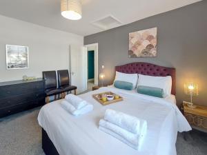 um quarto com uma grande cama branca e 2 almofadas em Margaret's Loft em Cheltenham