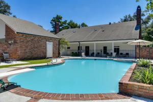 a swimming pool in front of a house at Stunning Baton Rouge Home with Pool Near LSU! in Baton Rouge