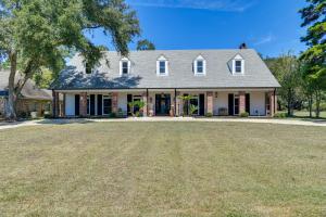 a house with a large yard in front of it at Stunning Baton Rouge Home with Pool Near LSU! in Baton Rouge