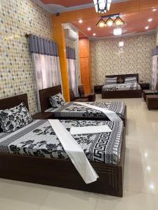 a room with three beds in a room with at Jinnah inn Guest House in Karachi