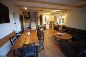 a living room with a wooden table and a fireplace at Ski House Szczyrk - Czyrna in Szczyrk