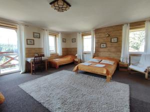 a bedroom with two beds and a table and chairs at Wichrowe Wzgorze in Stronie Śląskie