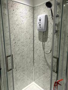 a shower with a glass door in a bathroom at Lanarkshire entire house sleeps 6, contractors, trade stays in Kilsyth