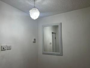 un espejo en una pared blanca con una luz en Lanarkshire entire house sleeps 6, contractors, trade stays, en Kilsyth