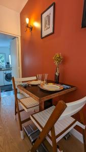 a dining room with a wooden table with chairs and a tableablish at "Maison verte" - terrasse - parking - 10min du métro in Montreuil +10 photos