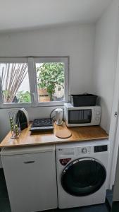 a small kitchen with a microwave and a stove at "Maison verte" - terrasse - parking - 10min du métro in Montreuil