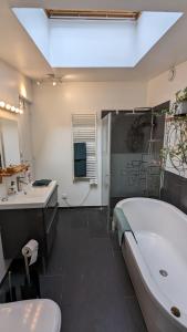 a bathroom with a tub and a toilet and a sink at "Maison verte" - terrasse - parking - 10min du métro in Montreuil