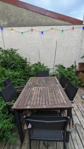 a wooden table and chairs on a deck with lights at "Maison verte" - terrasse - parking - 10min du métro in Montreuil