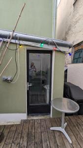 a patio with a table and a glass door at "Maison verte" - terrasse - parking - 10min du métro in Montreuil