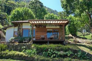 a small cabin with a porch in a garden at Chalé Leopoldo-Nas Nuvens in São Bento do Sapucaí +16 photos