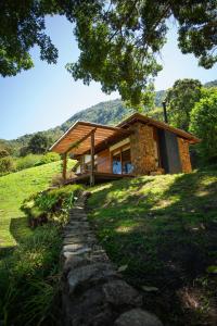a house on a hill with a stone path at Chalé Leopoldo-Nas Nuvens in São Bento do Sapucaí