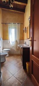 a bathroom with two sinks and a toilet and a window at B&B Camera delle Camelie in Palestrina