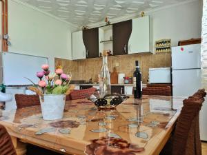 a kitchen with a wooden table with flowers on it at Vikendica Jovanovic in Bajina Bašta