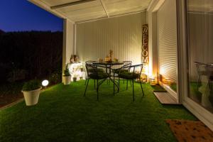 a patio with a table and chairs on the grass at Apartman Rita in Bjelovar