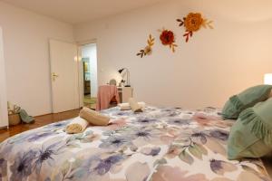 Apartman Rita في بييلوفار: غرفة نوم بها سرير كبير وعليه زهور